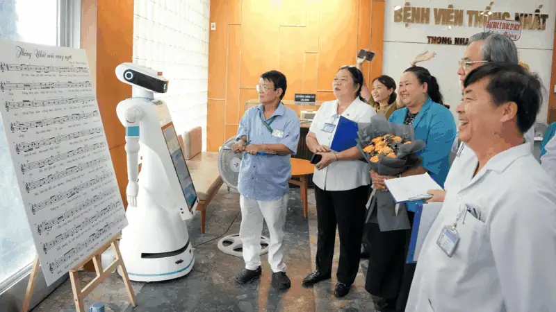 Hình ảnh các nhân viên y tế khám phá robot trình diễn thơ ca tại Bệnh viện Thống Nhất.