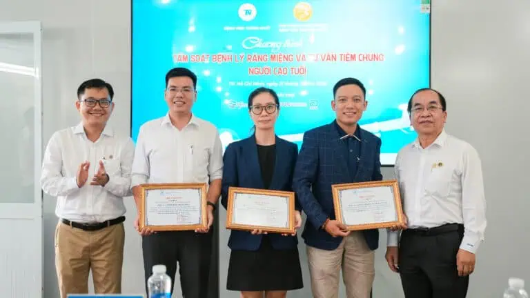 Alt: Hình ảnh các bác sĩ và đại diện nhận bằng khen tại sự kiện tầm soát bệnh lý răng miệng và tiêm chủng người cao tuổi.