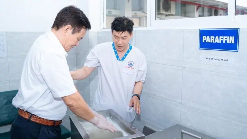 Ky thuat vien Vat ly tri lieu Phuc hoi chuc nang huong dan nguoi benh thuc hien lieu phap paraffin nhung sap trong dieu tri dau khop do thoai hoa